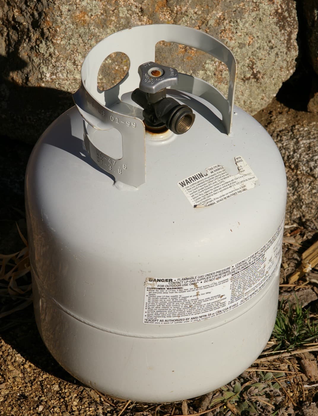 A steel propane cylinder fitted with an overfill protection device valve.