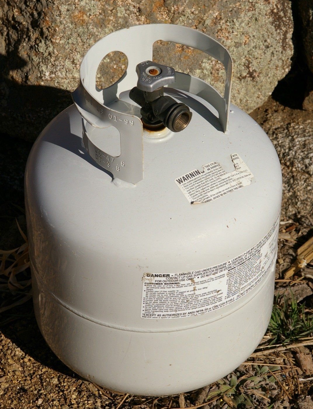 A steel propane cylinder fitted with an overfill protection device valve.